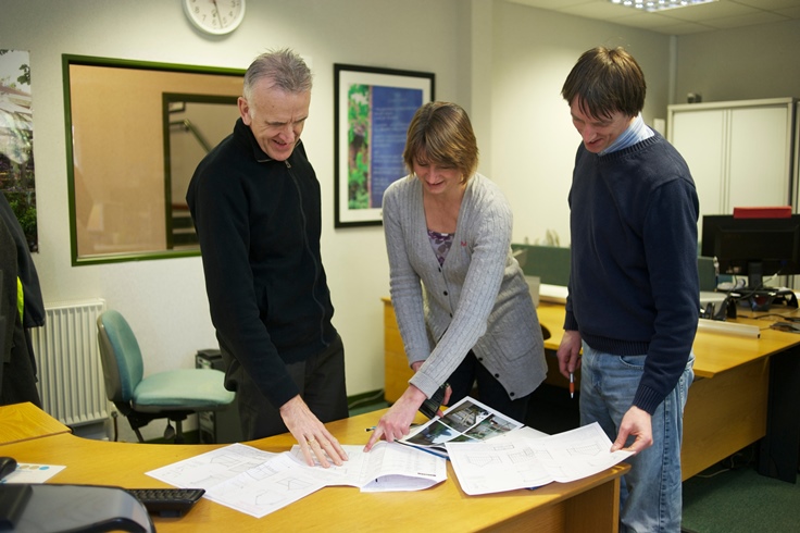 Design office team looking at greenhouse design plans