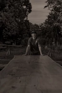 Oli Carter is standing by the end of the table he built for the Chelsea Flower Show. 