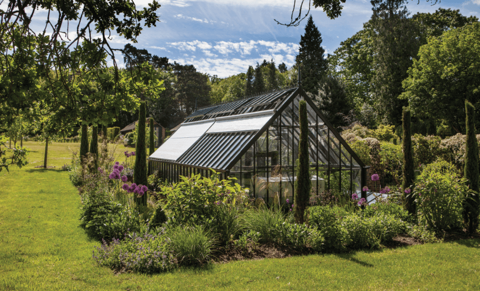 Two Greenhouse External Roof Shades on the side of a black aluminium greenhouse with one shade in the lowered position and one in the raised position