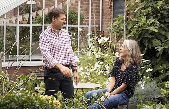 man and woman in cutting garden looking at each other laughing