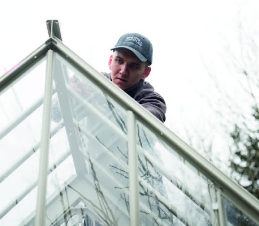 Man re-glazing Greenhouse